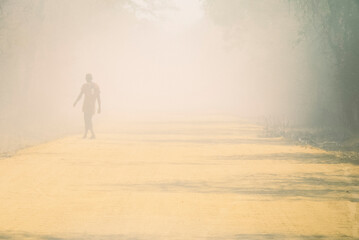 Road crossing the baobab walk in Madagascar as a truck passes and dust rises as a man walks.