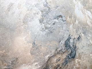 Obraz premium Spotted grey background from decorative plaster with abstract spots. Unusual texture of this wall with beautiful patterns, creative surface background. Finishing coating for building cladding