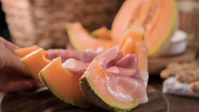Italian prosciutto crudo with melons. Slices of traditional ham wrapped around melons. Tasty appetizer. Food background. Close up. Snack for wine for an aperitif