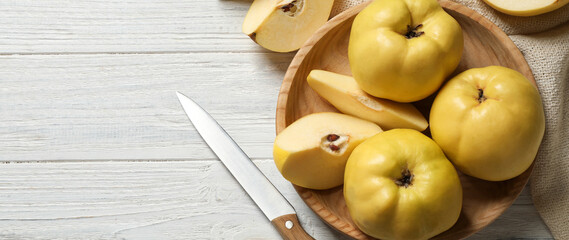 Fresh ripe organic quinces and knife on white wooden table, flat lay with space for text. Banner design
