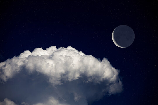 Fantasy night landscape, waning crescent moon surrounded by stars above cloud. Daydreaming image.