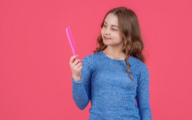 teen girl smile with curly hair hold comb on pink background