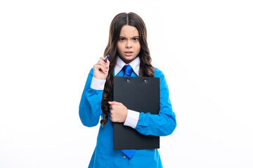 Serious angry teenager girl in shirt and tie wearing office uniform holding clipboard on white isolated background.