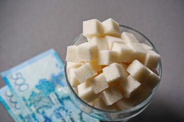 Almaty, Kazakhstan - 03.28.2022 : Kazakhstani money - tenge and sugar are on the kitchen table.