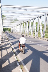 child on  or iron bridge or jembatan konstruksi besi di kali Luk Ulo, Kebumen, Jawa Tengah, Indonesia - obrazy, fototapety, plakaty