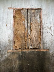 An old ruined window on grungy white wall