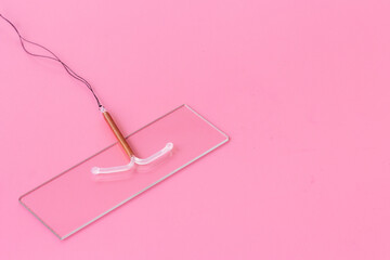 Intrauterine contraceptive device on medical glass. Gynecologist table
