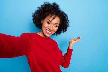 Photo of cute pretty young woman wear red sweater tacking selfie arm empty space isolated blue color background