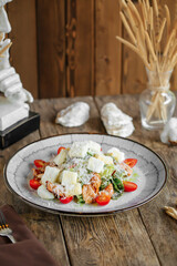 Portion of caesar salad with chicken on wooden table