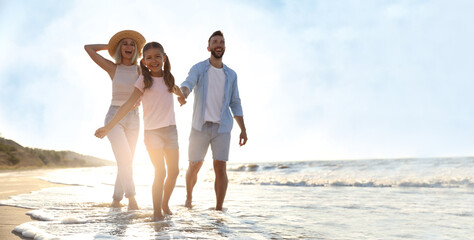 Happy family on sandy beach near sea, space for text. Banner design