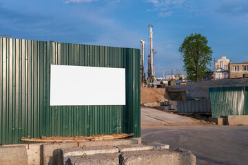 White blank poster with place for mockup fixed on steel temporary fence of construction site outdoor © Bonsales
