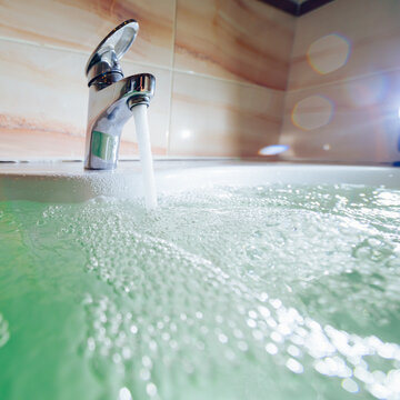 Single Handle Faucet Pouring Hot Water In A Bath Tub