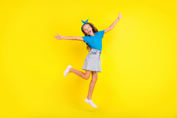 Fototapeta na wymiar Full length photo of excited crazy girl jump have fun raise hands freedom isolated on yellow color background