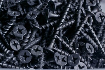 pile of black wood screws close up