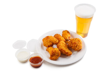 Set with chicken nuggets, sauces and plastic glass with beer.