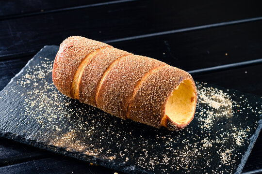 Trdelnik is a traditional sweet cake made from yeast dough held around a stick, then fried and sprinkled with sugar