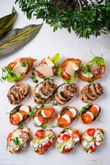 Brushetta set for wine. Variety of small sandwiches with prosciutto, tomatoes, cheese, herbs