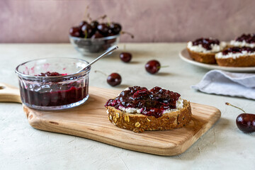 Wholewheat toasts with ricotta and homemade sweet cherry jam - obrazy, fototapety, plakaty