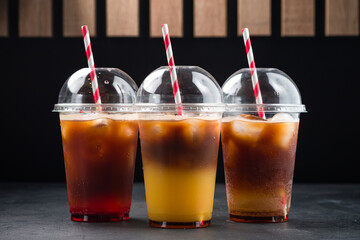Various iced layered coffee drinks with orange juice and syrups