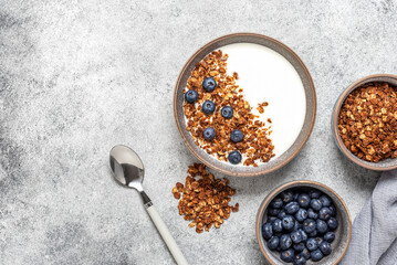 Yogurt, granola and blueberries. Top view, copy space. Gray concrete background.
