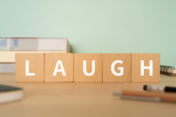 「LAUGH」と書かれたブロックが置かれたデスク