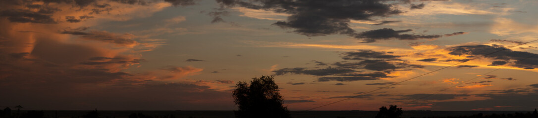 Landscape at sunset. Tragic gloomy sky. The village in the Budjak steppe. Panorama. Crimson twilight.
