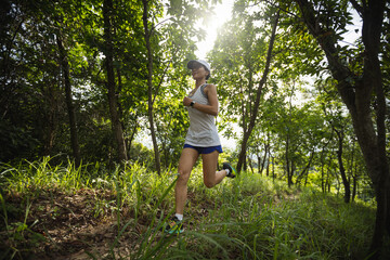 Obraz na płótnie Canvas Woman runner running on forest trail