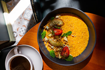 Pumpkin porridge with strawberries, apple, mint, avocado