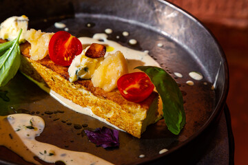 Fried fish fillet with cheddar, blue cheese, tomatoes, basil and sauce