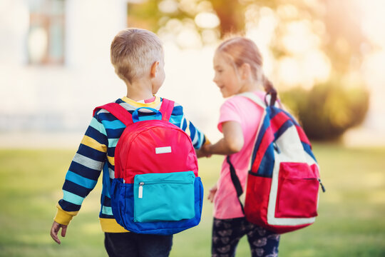 Girl And Boy Going To The School Holding Hands To Study At It.