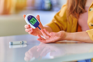 Female using glucose meter for measuring and monitoring blood level. Healthcare and mellitus diabetes treatment - obrazy, fototapety, plakaty