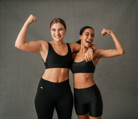 Two female friend flexing there arm muscles and showing there toned bodies