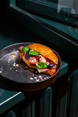 Sandwich with prosciutto, tomatoes, basil, almond slices and pepper