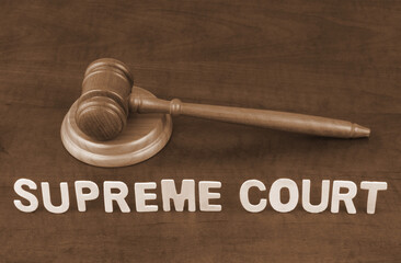 Supreme court and laws concept. Wooden judge gavel and letters supreme court.