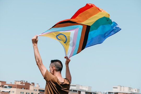 waves a progress pride flag in the air