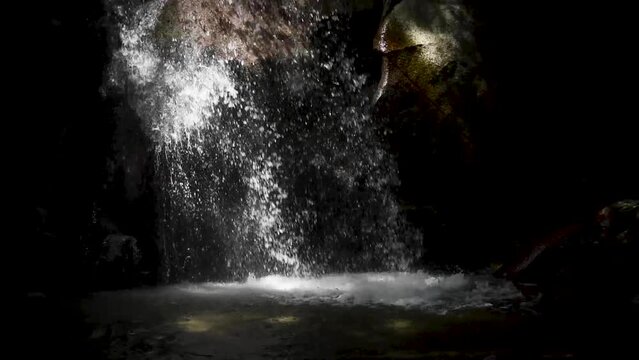 Water falling into a waterfall basin in the dark background 2