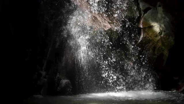 Water falling into a waterfall basin in the dark background 5