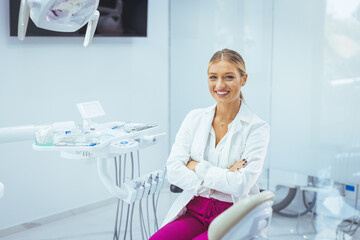 Portrait of a Caucasian woman dentist, sitting in her office next to a dentist chair, smiling....