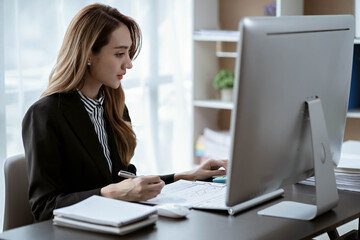 Asian businesswoman in formal suit in office happy and cheerful during using smartphone and working