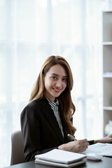 Asian businesswoman in formal suit in office happy and cheerful during using smartphone and working