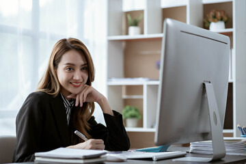 Asian businesswoman in formal suit in office happy and cheerful during using smartphone and working