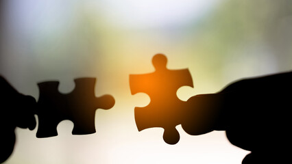 Closeup hand of woman connecting jigsaw puzzle