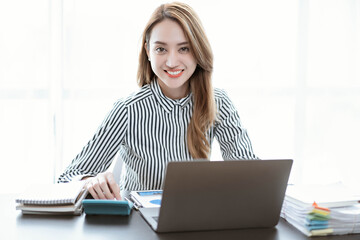 Asian businesswoman in formal suit in office happy and cheerful during using smartphone and working