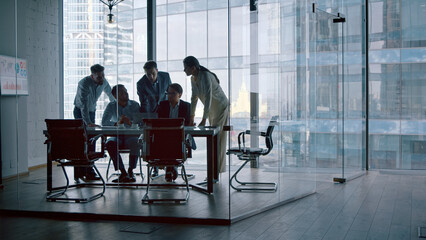 Corporate team discussion using computer technology while sitting at desk