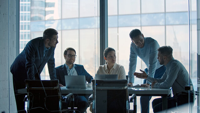 Group of business people working at a table at meeting room. Mature business people working with laptop