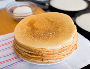 stack of appetizing flour pancakes in the kitchen during cooking