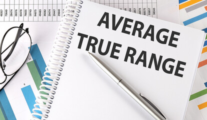 ATR Average True Range , pen and glasses on the chart, business concept