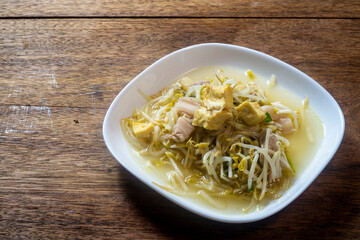 Stir fry bean sprouts with tofu on a wooden table. Healthy menu.