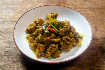 Stir-fried spicy duck curry paste on a wooden table. Ready to eat.