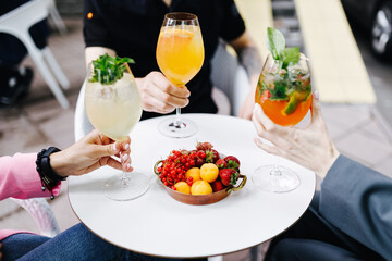 three people at a white table drinking cocktails